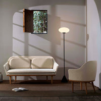 "Modern cream sofa and chair set with natural wood accents against a neutral wall, featuring soft light and minimalistic design."