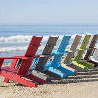 "Colorful Adirondack chairs in red, gray, blue, green, and beige arranged on a beach shoreline with ocean waves."