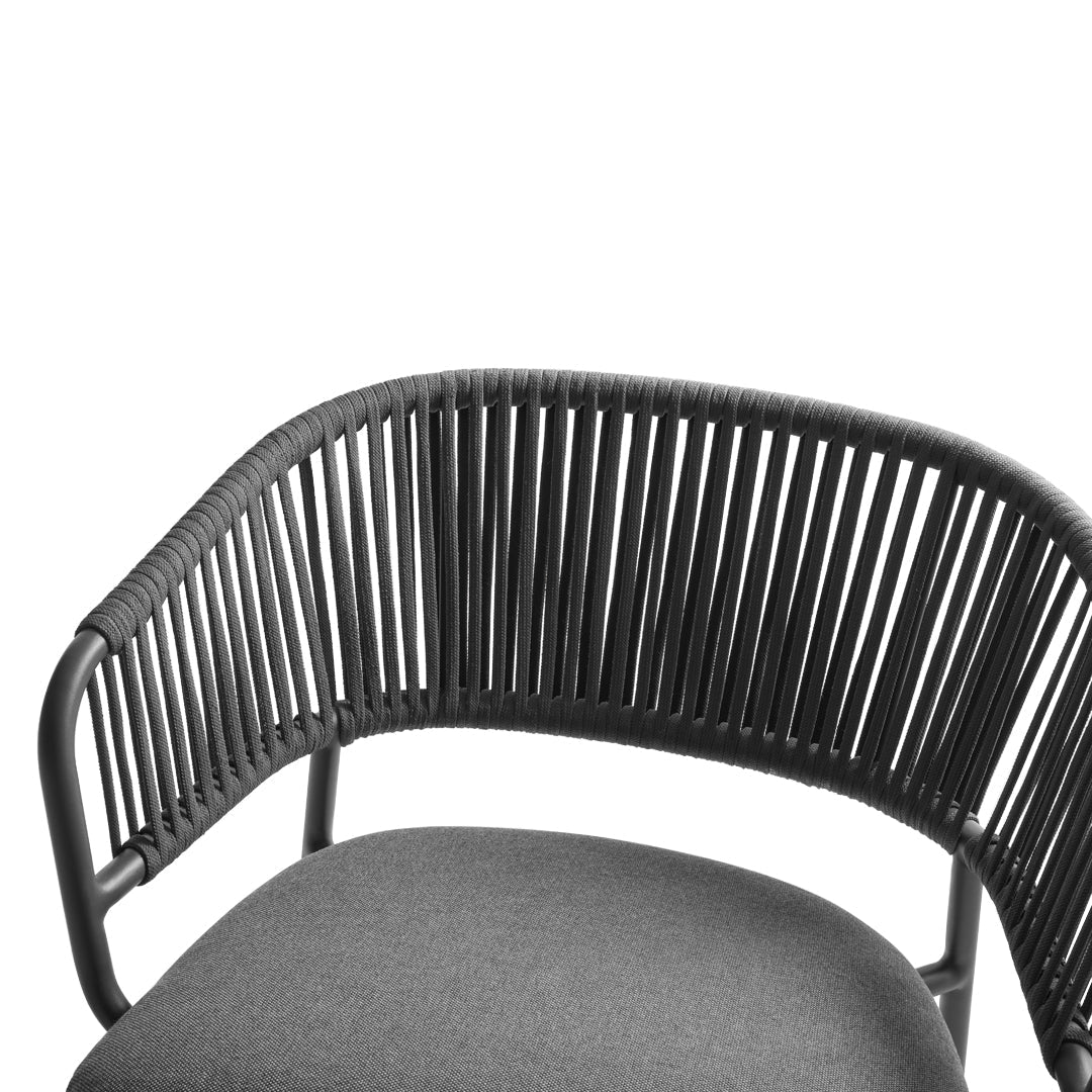 Black rattan chair with a sleek, modern design and a textured, dark gray seat cushion for stylish seating.