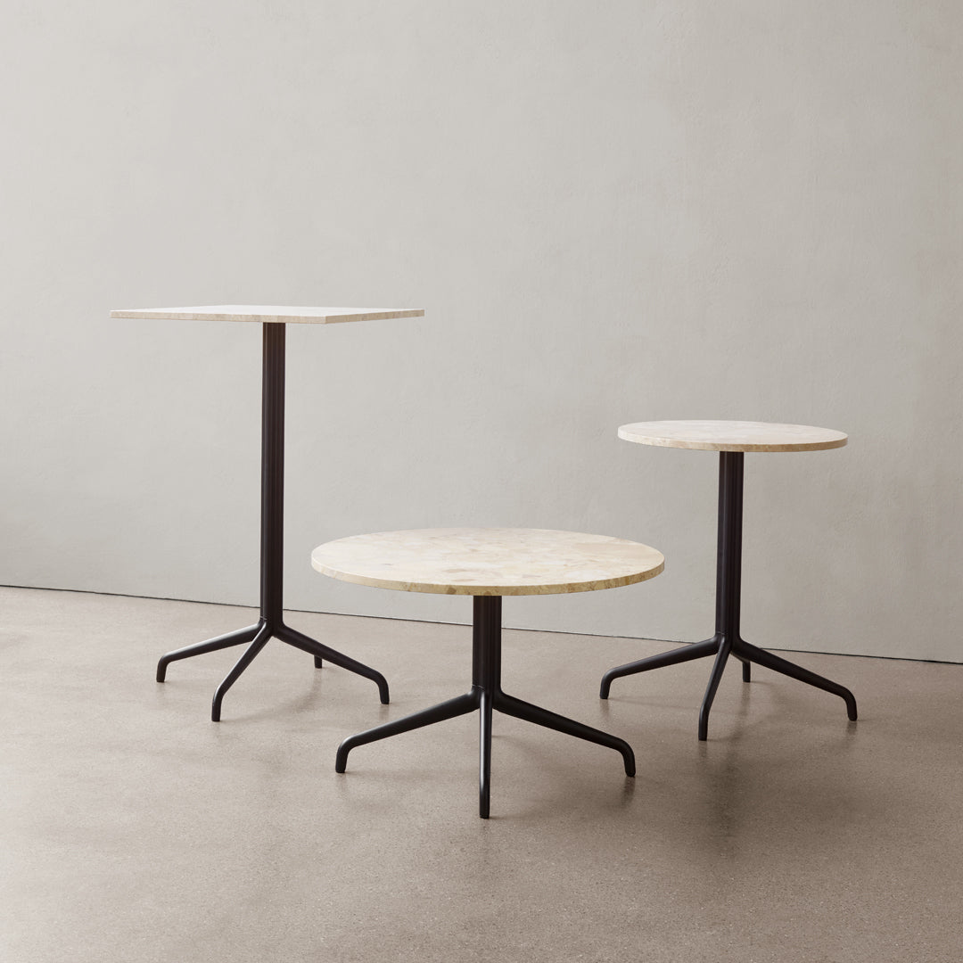 Set of three modern tables featuring round white marble tops and sleek black metal legs. Elegant and contemporary design.