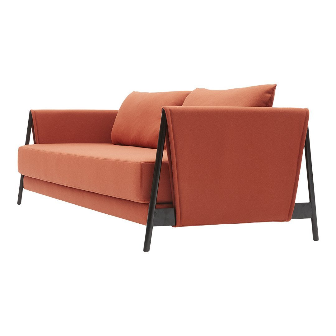 Rust-orange fabric couch with sleek black metal legs and minimalist design. Soft cushions for added comfort.