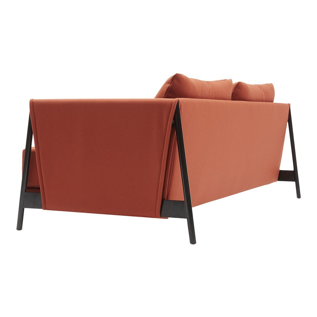 Rust-orange sofa with simple, clean lines and black metal accents, featuring a smooth, textured fabric.
