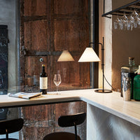 "Elegant black and white lamp with a sleek geometric design against rustic wooden backdrop."
