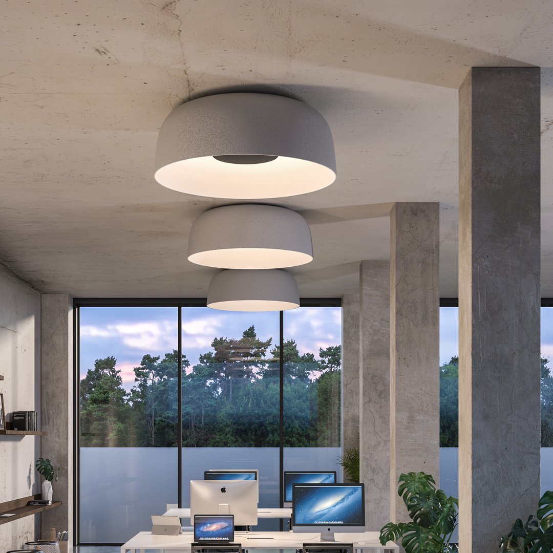 Modern white ceiling lights with sleek circular designs in a minimalist office setting. Soft gray tones complement the space.