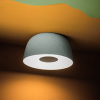 "Modern gray ceiling lamp with a textured finish, featuring smooth white interior and warm orange backdrop."