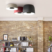 Ceiling lamp with three shades: white, red, and dark gray on a textured brick wall background. Modern and stylish design.