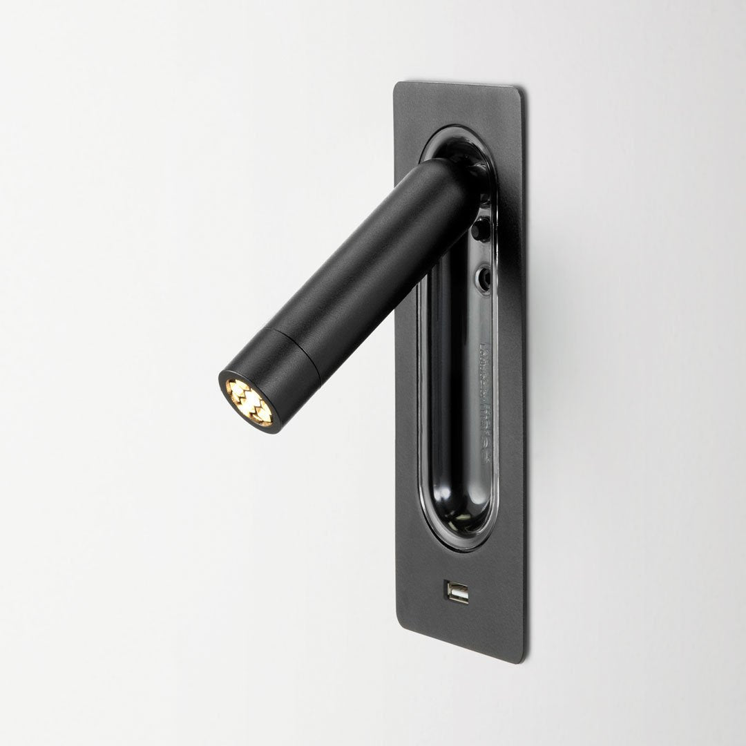 Black wall-mounted light fixture with sleek cylindrical design and subtle matte finish. Modern minimalistic style.