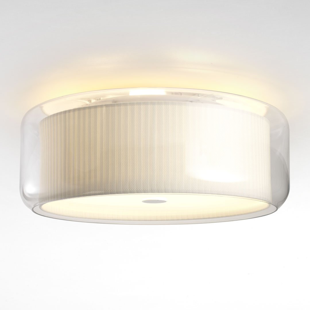 Modern round ceiling light with a clear glass shade and soft cream ribbed pattern, casting a warm glow.