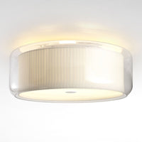 Modern round ceiling light with a clear glass shade and soft cream ribbed pattern, casting a warm glow.