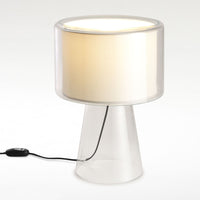 Clear glass lamp with a white shade, featuring a minimalist design and soft beige ambiance. Ideal for modern decor.