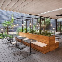 "Modern outdoor seating with natural wood tones, sleek black metal accents, and lush green plants."