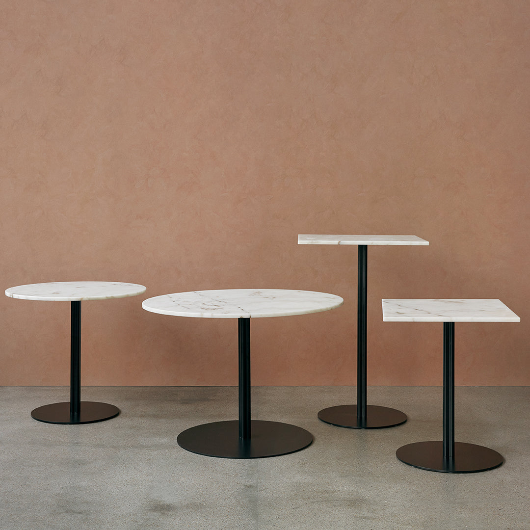 Modern side tables featuring white marble tops with subtle gray veining and sleek black metal bases.