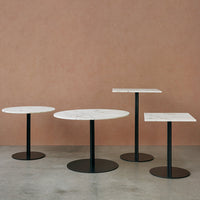Modern side tables featuring white marble tops with subtle gray veining and sleek black metal bases.