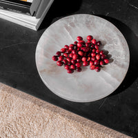 Round, marbled gray plate featuring vibrant red berries, set against a dark background. Elegant and modern design.