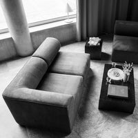 Black and gray modern sectional sofa with minimalist design, set against a neutral backdrop. Perfect for contemporary spaces.