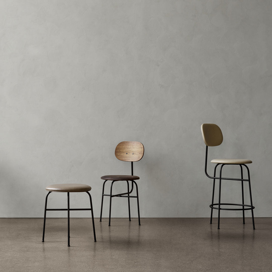 Set of three modern stools featuring beige, brown, and cream colors with sleek black metal legs against a light gray background.