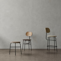 Set of three modern stools featuring beige, brown, and cream colors with sleek black metal legs against a light gray background.