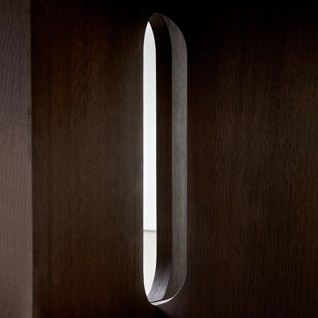 Sleek, minimalist design with a dark wood texture and smooth, elongated light cutout. Modern and chic.