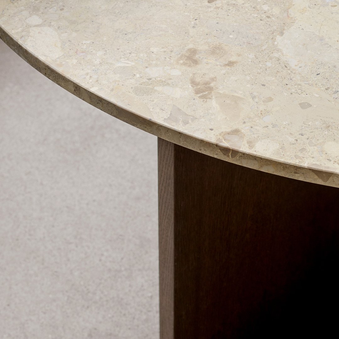 Round beige marble tabletop with subtle speckles, paired with a dark wooden base. Elegant and modern design.