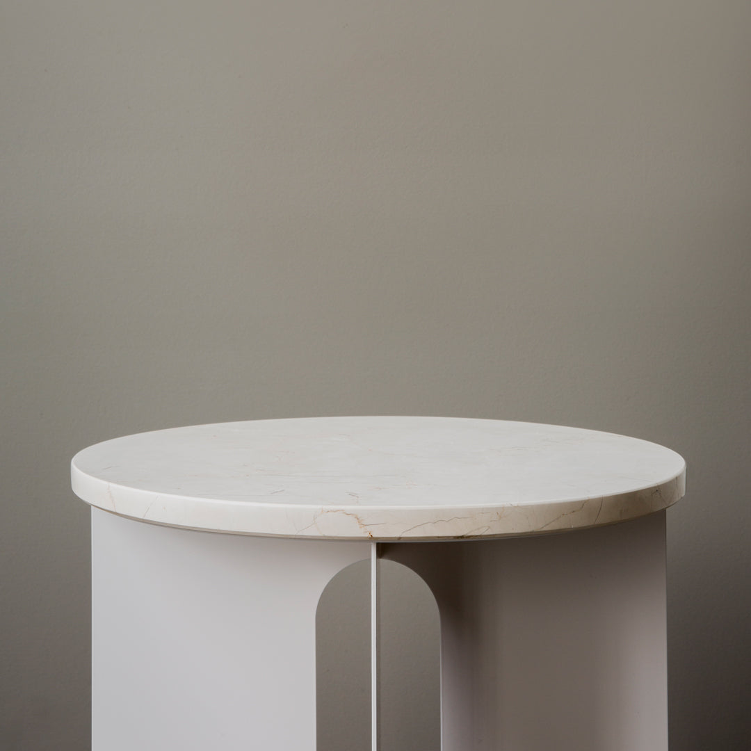 Round white marble top table with sleek gray legs, featuring a minimalist design and smooth surface.