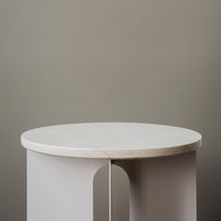 Round white marble top table with sleek gray legs, featuring a minimalist design and smooth surface.