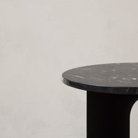 Black marble tabletop with subtle white veining, paired with a sleek black base. Modern and elegant design.