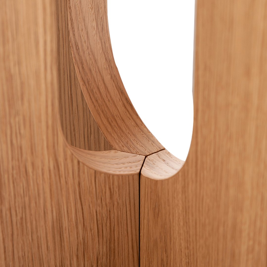 Close-up of natural oak wood with smooth, curved cutout and warm tones, showcasing fine grain patterns.