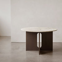 Round marble top table with a dark wood base featuring a circular cutout, showcasing a modern minimalist design.
