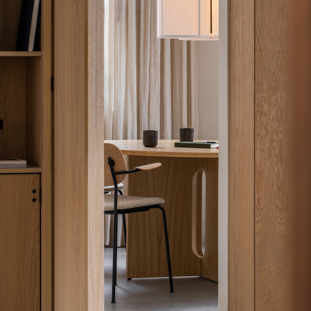 Modern office with neutral tones, warm wood textures, soft fabric curtains, and a minimalist chair design.