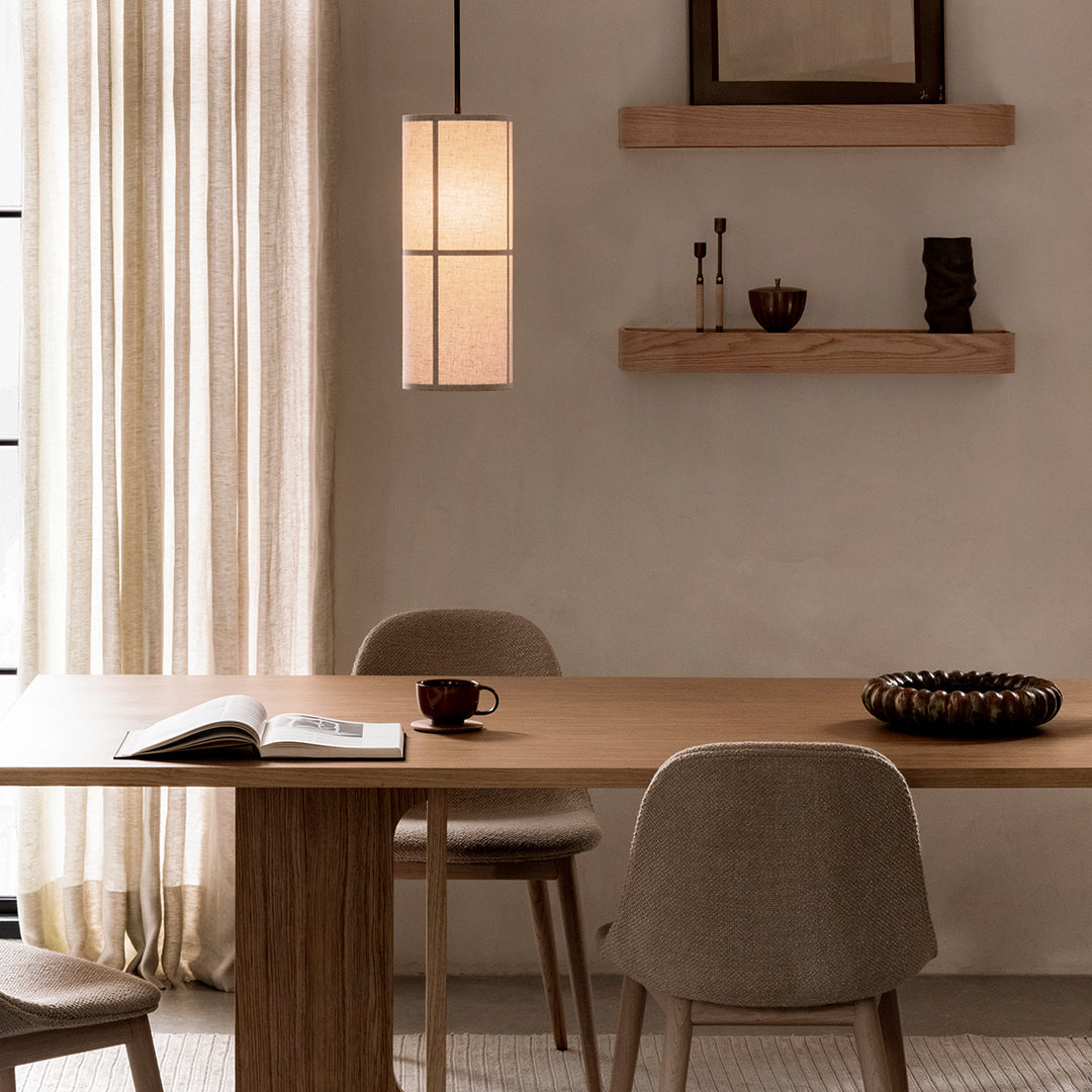 Modern dining area with warm wood tones, cream curtains, and minimalist decor in soft neutral hues.