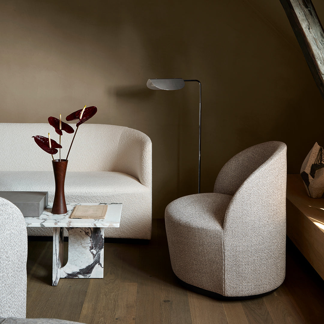 Neutral beige and white tones with smooth textures in a modern living room setting, featuring curved furniture.