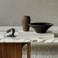 Black bowl and textured brown vase on a marble table, featuring subtle gray and cream tones in a chic, minimalist design.