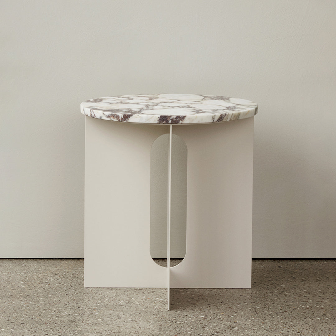 Round marble top in white and grey with minimalist cream base featuring a cutout design. Perfect for modern decor.