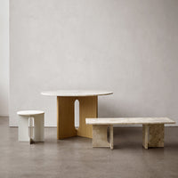 Modern furniture set featuring a round white tabletop, a yellow base, and textured stone patterns in neutral tones.