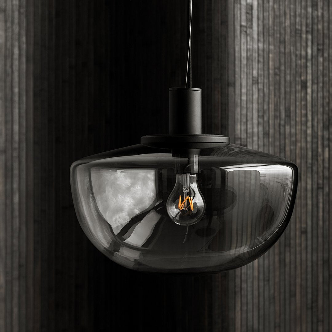 "Modern black glass pendant light with sleek curves and a minimalist design."