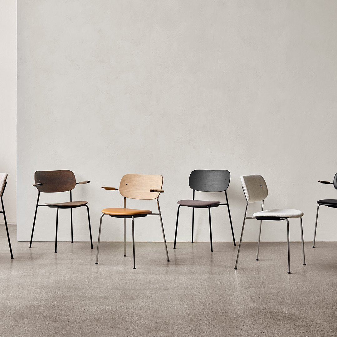 "Variety of modern chairs in colors: brown, light tan, grey, orange, white, and black, featuring sleek minimalist designs."