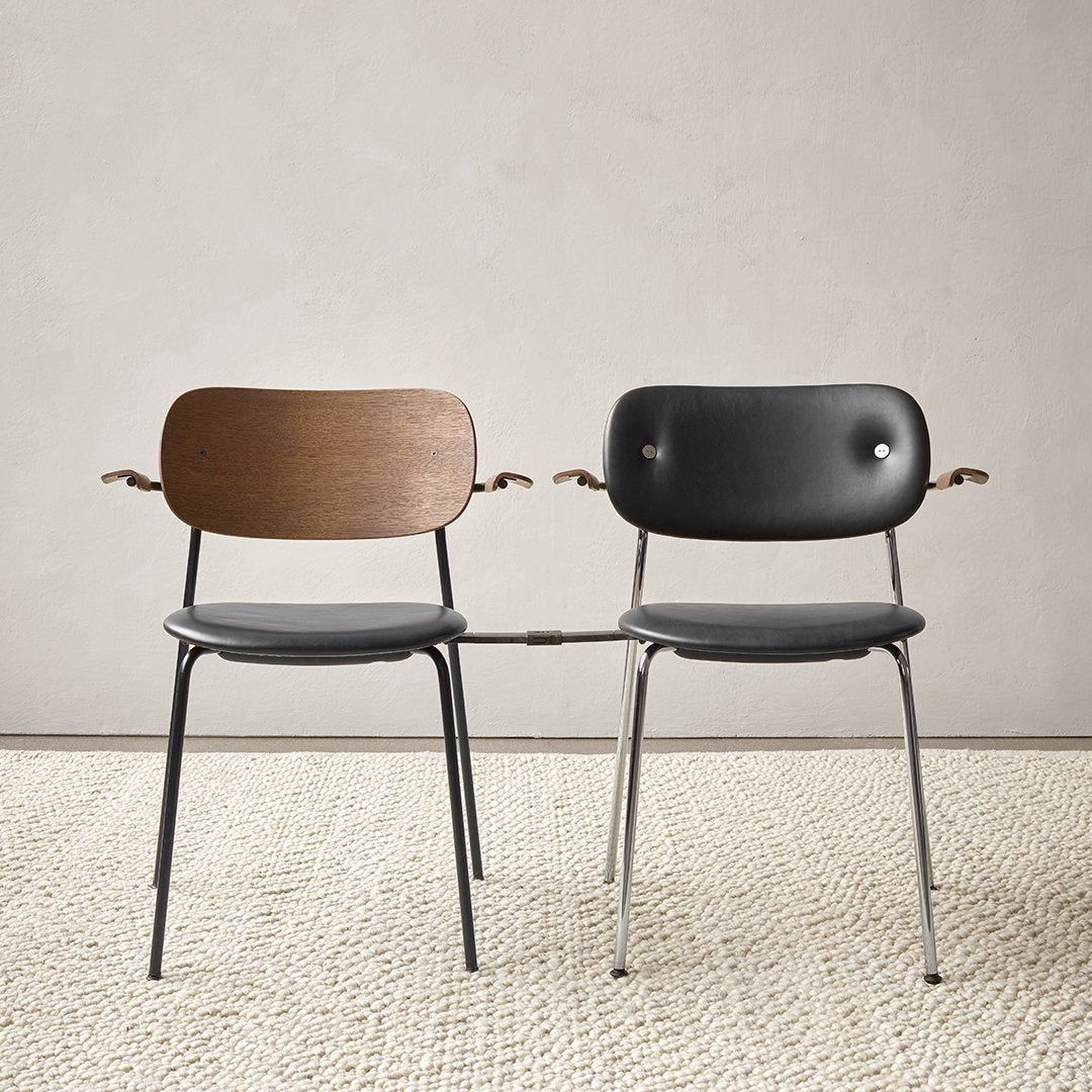 Two stylish chairs: one with a natural wood back and a black seat, the other fully upholstered in sleek black.