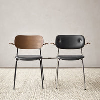Two stylish chairs: one with a natural wood back and a black seat, the other fully upholstered in sleek black.