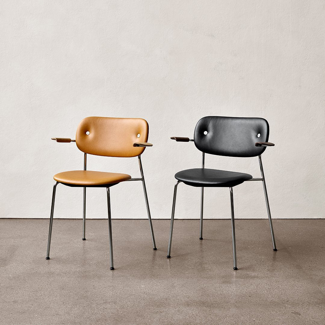 Tan and black modern chairs with sleek metal legs, featuring minimalist design and rounded patterns.