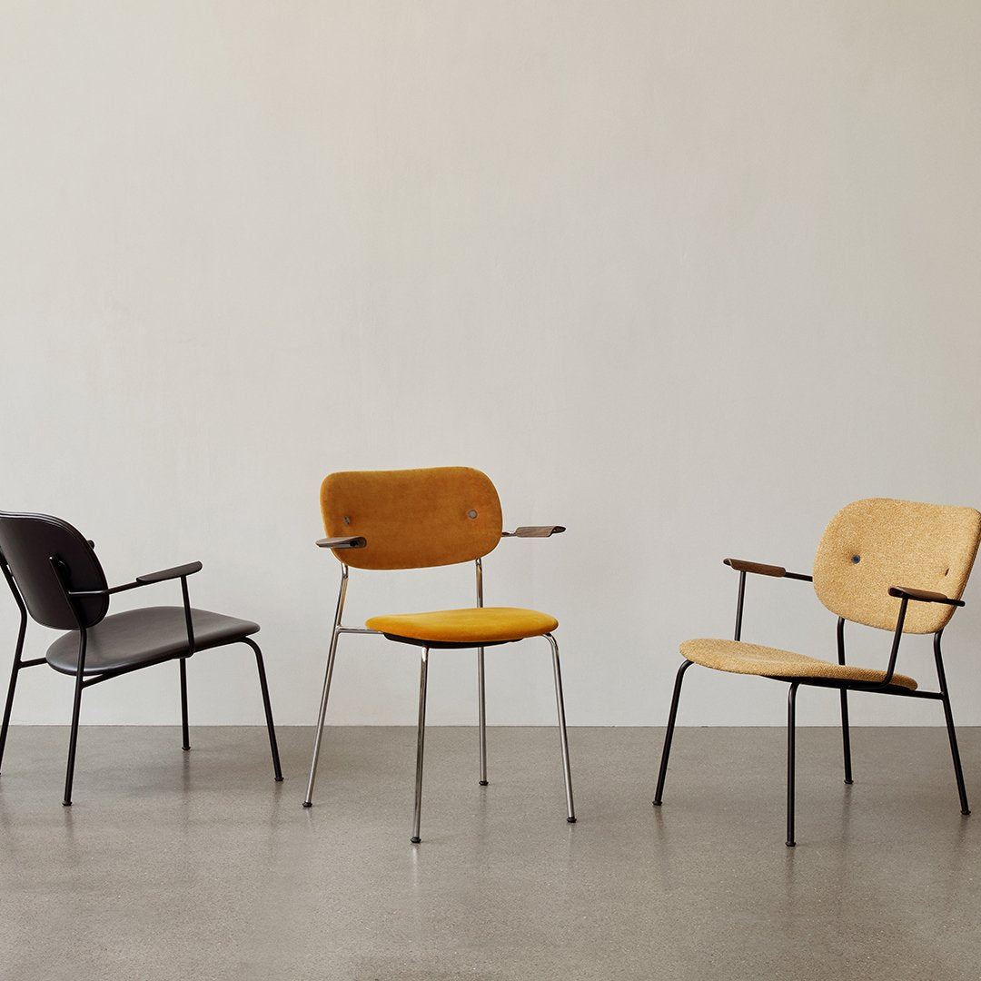Set of three chairs in black, natural wood, and mustard yellow, showcasing modern design and varying textures.