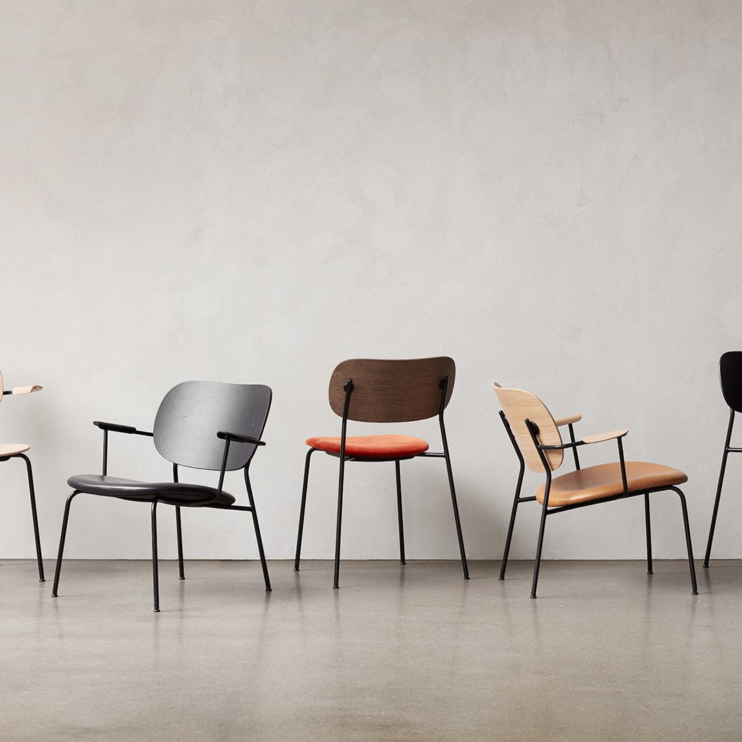 "Modern chairs in black, gray, brown, and natural wood, featuring sleek lines and soft fabric upholstery patterns."
