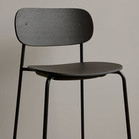 Minimalist black wooden chair with a smooth, matte finish and sleek, curved lines. Perfect for modern decor.