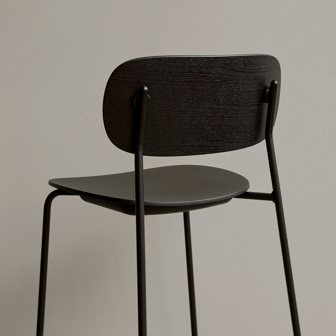 Black wooden chair with a smooth finish, featuring a minimalistic design and clean lines against a neutral background.