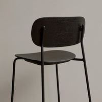 Black wooden chair with a smooth finish, featuring a minimalistic design and clean lines against a neutral background.