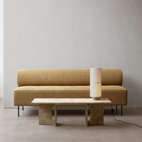 Yellow textured sofa with minimalist design, paired with a sleek wooden table and a modern lamp.