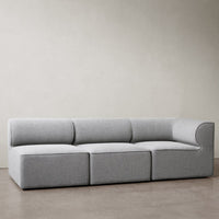Modern gray sectional sofa with a sleek, minimalist design and soft fabric upholstery, perfect for contemporary spaces.
