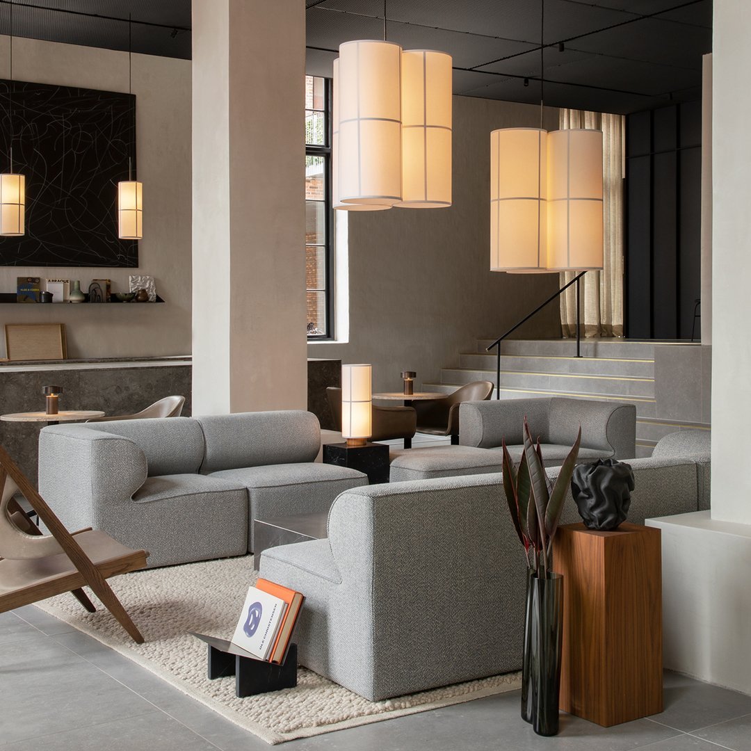 Modern gray sectional sofa with clean lines, complemented by warm wooden accents and soft, neutral lighting.