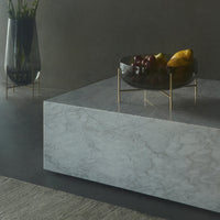 Elegant gray marble surface with subtle veining, complemented by a sleek gold-accented bowl of vibrant fruits.
