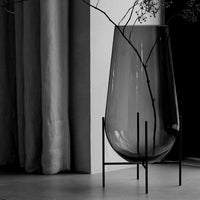 Elegant black and clear glass vase with a minimalist black stand, showcasing a sleek, modern design.