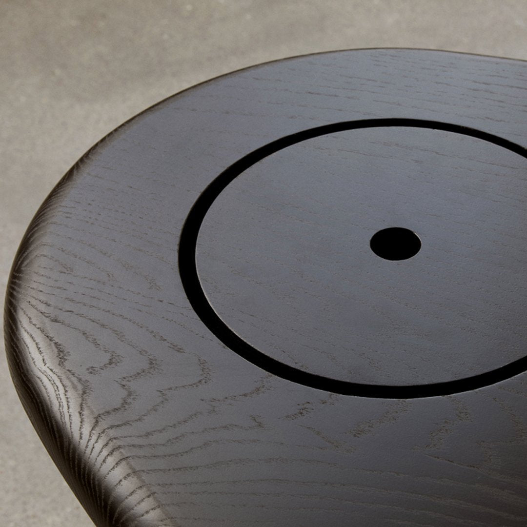 Black wood surface featuring a circular carved pattern with subtle grain texture, perfect for modern decor.
